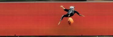 Child in Halloween Skeleton Costume Jumping in Air