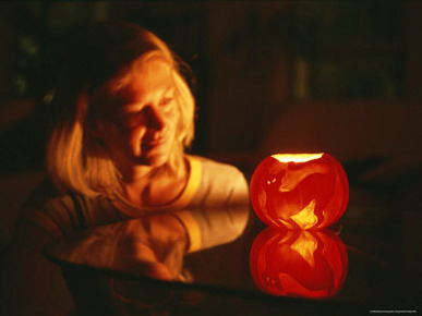 A Woman Illuminated by a Halloween Jack-O-Lantern