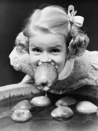 Girl Bobbing Apples at Halloween Party